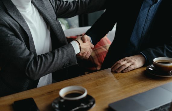 two-businessmen-shaking-hands-as-sign-agreement